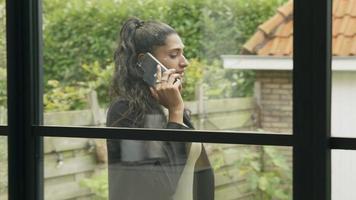 Mujer llamando con smartphone caminando en el jardín video