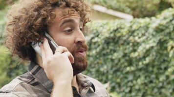 uomo in giardino che chiama con lo smartphone video