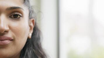 Close up of right half of womans face looking into camera lens video