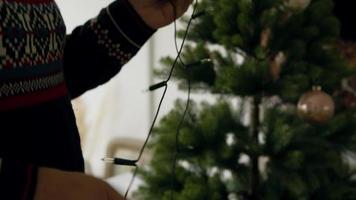 Man disentangling cable and woman decorating Christmas tree with bauble video