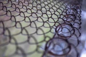 Wire fence with futsal field on background photo