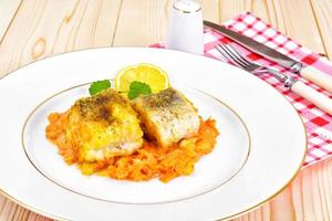 pescado en griego con cebolla y zanahoria foto