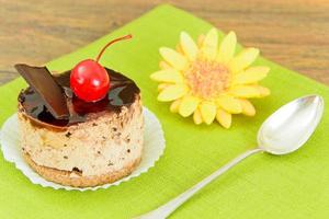 pastel con cerezas y chocolate, cupcake sobre fondo de madera. foto