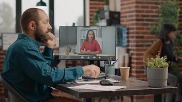 homem de negócios usando videochamada para falar com uma mulher no computador video