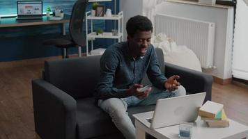 empresário afro-americano em videochamada remota de sua sala de estar