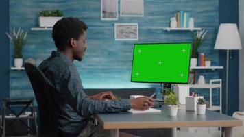 svart man skriver och använder persondator med mock up chroma key display video