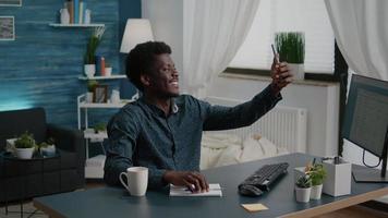 autêntico homem negro afro-americano tirando selfie em uma sala de estar aconchegante video