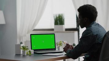 afrikansk amerikansk man använder mockup laptop med grön skärm
