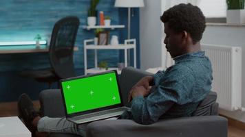 African american man working with chroma key isolated laptop dispaly video