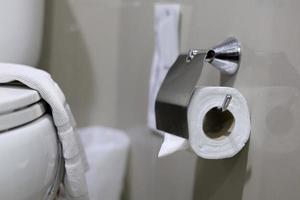 Clean toilet paper in the bathroom. Being folded and being used for the hotel guests photo