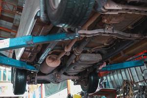 The undercarriage of a car with a jack is lifted for repairs. photo