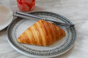 Croissant recién horneado brillante en la cafetería. foto