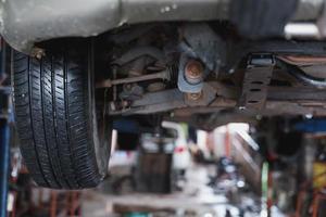 The undercarriage of a car with a jack is lifted for repairs. photo