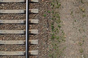 Railroad top view, flat lay. Part of the track for trains. Aerial view of a railway from a drone. Background with space for text. Shiny iron rails and concrete sleepers. photo