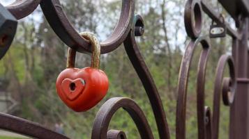 Red padlock metal love heart shaped lock on the bridge. The concept of love. Valentine's day background. photo