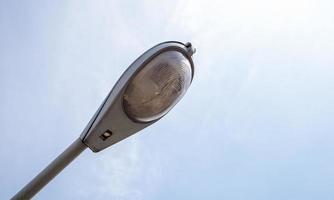 Street lamp close up. Big street lights at a big highway interchange. Close-up. Modern street lamp. Electric old lamp of street lighting on the background of blue sky and clouds during the day.
