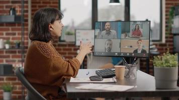 Entrepreneur using video call on computer to talk to colleagues