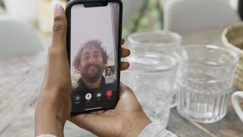 Close up of hands of woman holding smartphone having video call with man