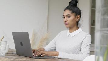mujer sentada en la mesa escribiendo en el portátil video