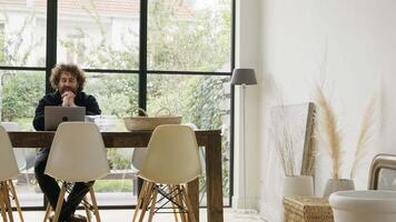 Man sitting at table having video call on laptop