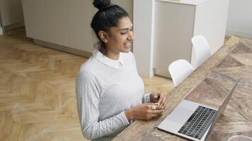 mujer en la mesa habla vívidamente mientras tiene videollamada video