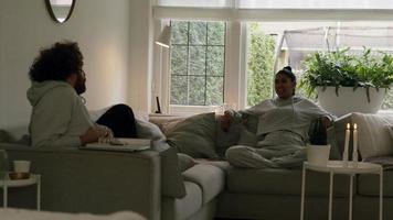 hombre y mujer sentados y hablando en el sofá de la esquina video