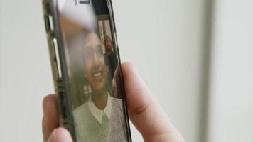 Close up of hand of man holding smartphone having video call with woman
