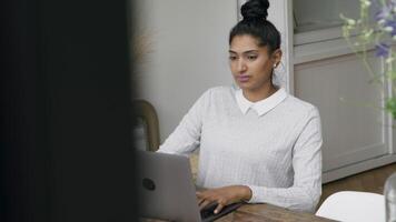 vrouw typt op laptop en kijkt naar scherm video