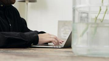 Man sitting at table typing on laptop video