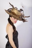 Beautiful woman with feather hat, and red lips. Retro fashion photo