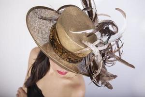 Beautiful woman with feather hat, and red lips. Retro fashion photo