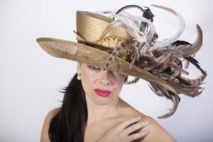 Beautiful woman with feather hat, and red lips. Retro fashion photo