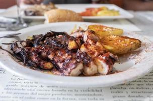 grilled octopus dish with a special sauce accompanied by roasted potatoes