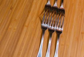 Dessert forks on bamboo kitchen board photo