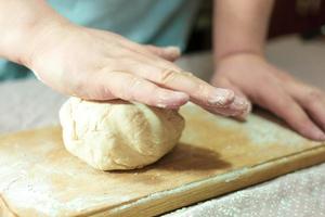 Knead the dough on a wooden board photo