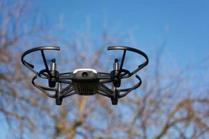 drone volando contra el cielo y los árboles foto