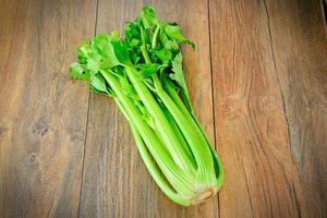 Fresh Juicy Celery on Woody Background photo