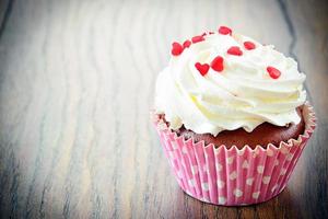 Pastel con crema, cupcake sobre fondo amaderado foto