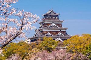 castillo de hiroshima durante la temporada de los cerezos en flor foto