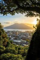 Kagoshima city downtown skyline cityscape  with Sakurajima Volcano in Kyushu, Japan photo