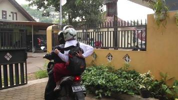 Mother takes her child to school by motorbike, Batang, Indonesia, October 2, 2021 video