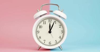 Alarm clock isolated on a pink blue background, Showtime 12.00 am or pm, Time lapse 2 hour. video