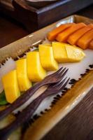 Close up on yellow mango on fruit dish. photo
