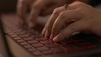 close-up de mãos de mulher digitando em um teclado de computador laptop no escritório.