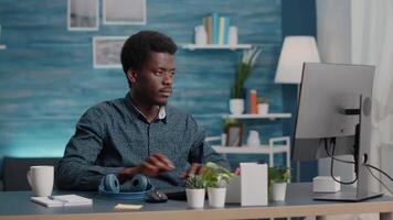 A manager using headphones to listen to music while working from home on a computer video