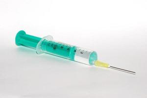 filled syringe on white background photo
