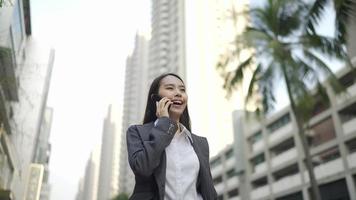 mujer de negocios, ambulante, y, hablar, en, un, smartphone video