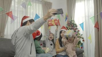 familia feliz, con, navidad, sombreros, hablar, selfies, con, smartphone video