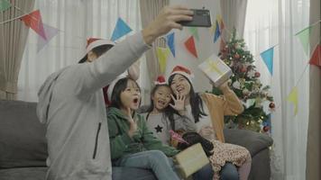 familia feliz, con, navidad, sombreros, hablar, selfies, con, smartphone video