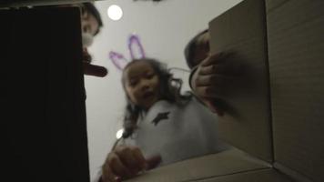 Cute girl opening a Christmas present with her family. POV from inside the box. video